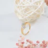 a gold ring with diamonds and a white ball of straw